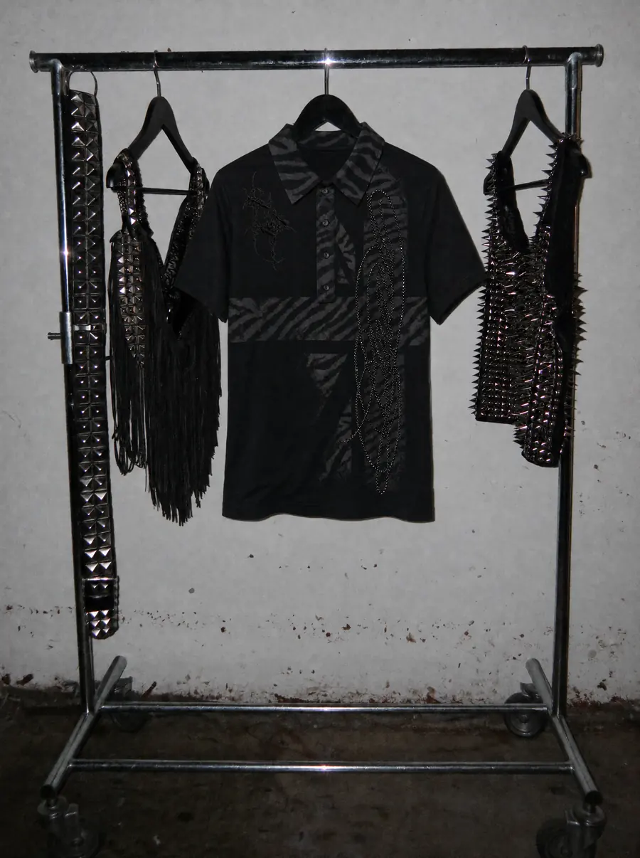 Stender in showroom con la polo custom del Drop 02 e gli accessori borchiati della collezione Uneven.